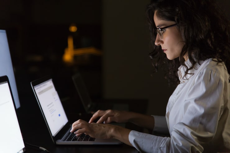 Person typing fiercely on a laptop in the dark